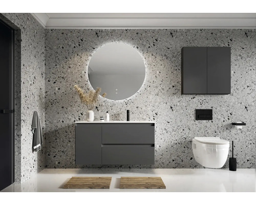 Badezimmer mit Waschtisch, Spiegel, Hängeschrank und wandhängendem WC vor einer Terrazzo-Wand