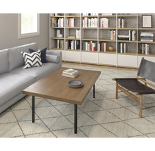 Salon avec canapé, table en bois, bibliothèque et fauteuil sur un tapis.