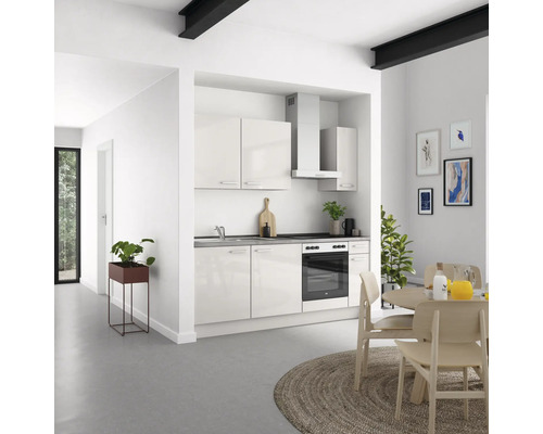 Helle Küche mit Küchenschränken, Dunstabzugshaube und Essbereich in einem hellen Raum.