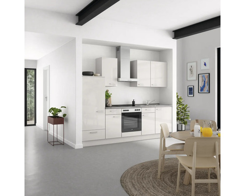 Cuisine claire avec placards intégrés, évier, cuisinière et hotte aspirante dans une pièce aménagée de façon moderne.
