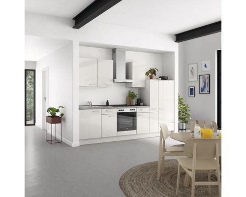 Cuisine moderne avec façades blanches brillantes, hotte aspirante et table à manger