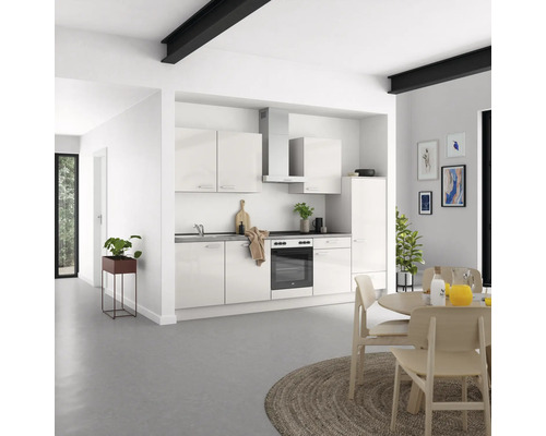 Cuisine claire avec armoires encastrées, hotte aspirante et table à manger dans un espace de vie moderne.