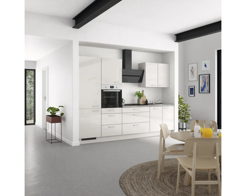 Cuisine claire avec armoires encastrées, hotte aspirante et table à manger dans un espace de vie moderne.