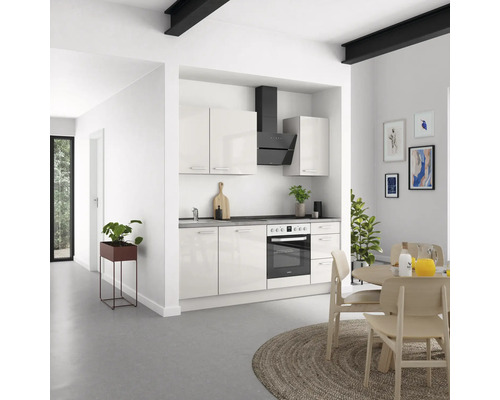 Cuisine claire avec cuisine intégrée, hotte aspirante et table à manger.