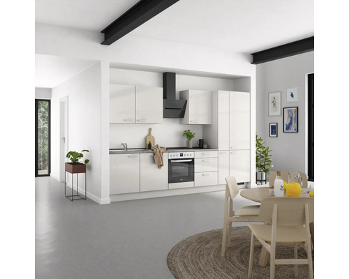 Cuisine moderne et lumineuse avec armoires encastrées, hotte de cuisine et table à manger dans la salle à manger