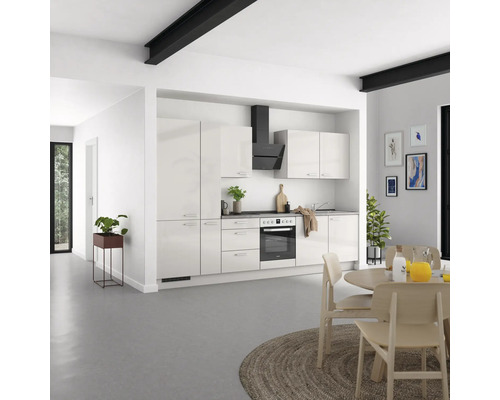 Cuisine claire avec armoires de cuisine, hotte aspirante et table à manger dans une pièce aménagée de façon moderne.