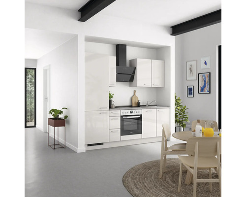 Cuisine claire avec kitchenette, hotte aspirante, table à manger et décoration dans un espace moderne.