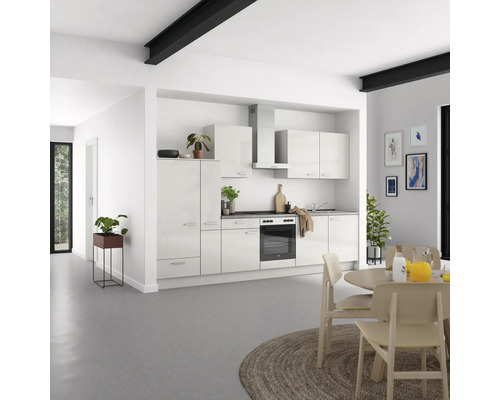 Cuisine moderne avec armoires blanches, table à manger et chaises dans une pièce lumineuse.