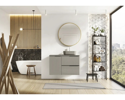 Salle de bain lumineuse avec baignoire, meuble-lavabo, miroir et étagère