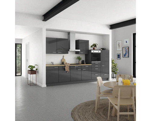 Moderne Küche mit grauen Schränken, Holzarbeitsplatte und Esstisch mit Stühlen in einem hellen Raum.