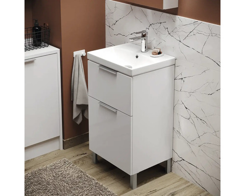 Salle de bains avec meuble sous-vasque à deux tiroirs, robinet et porte-serviettes