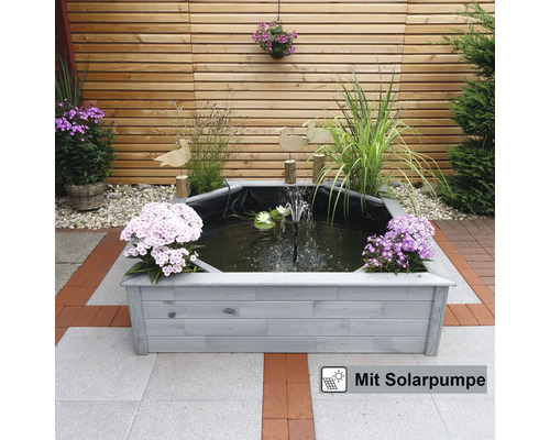 Bassin octogonal avec pompe solaire et bordure en bois dans le jardin