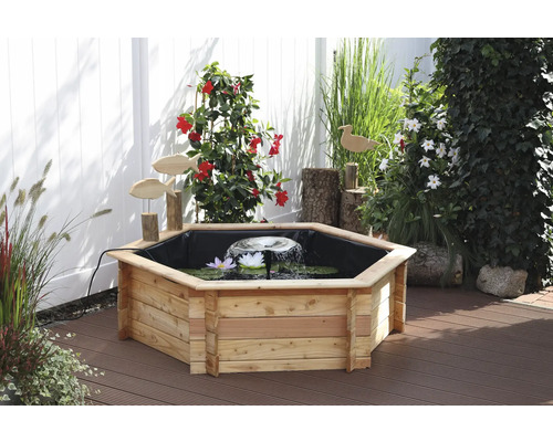 Holzteich mit Seerosen, Springbrunnen und Holzfiguren im Garten