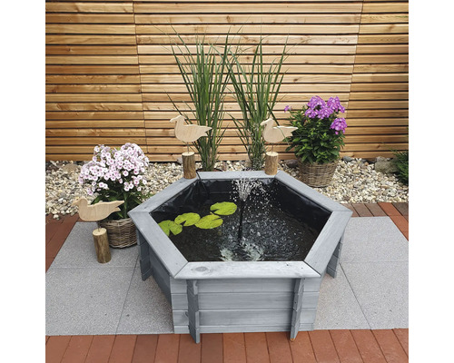 Scène de jardin avec bassin en bois, jet d''eau, feuilles de nénuphar et décoration