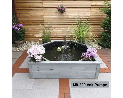 Gartenteich mit Pumpe und Holzrahmen im Garten