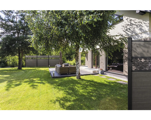 Garten mit Rasenfläche, Holzzaun und Sitzgruppe auf einer Terrasse