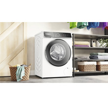 Machine à laver dans une buanderie lumineuse avec des étagères et un panier à linge