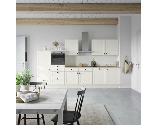 Cuisine claire avec four encastrable, hotte aspirante et table à manger