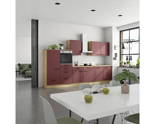 Moderne Küche mit Küchenschränken, Dunstabzugshaube und Esstisch in einem hellen Raum.