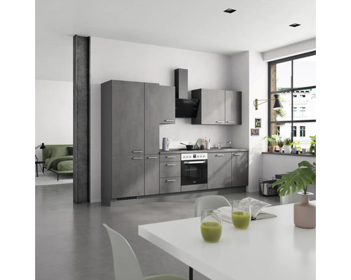 Cuisine moderne avec façades grises, hotte aspirante et table à manger blanche dans une pièce lumineuse.