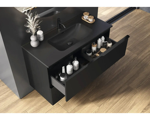Badezimmer mit schwarzem Waschtischunterschrank, offenem Schubfach und Pflegeprodukten