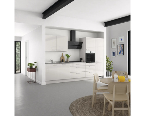 Cuisine lumineuse avec armoires de cuisine, hotte aspirante et table à manger dans un espace moderne.