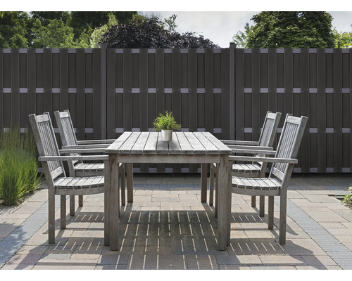 Scène de jardin avec table en bois, chaises et clôture