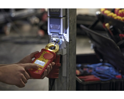 Une personne mesure l''intensité du courant avec un appareil de mesure de courant Wiha sur une prise de courant