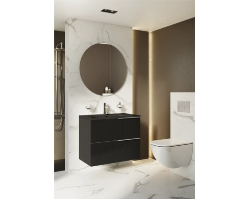 Badezimmer mit schwarzem Waschtischunterschrank, rundem Spiegel und wandhängendem WC.