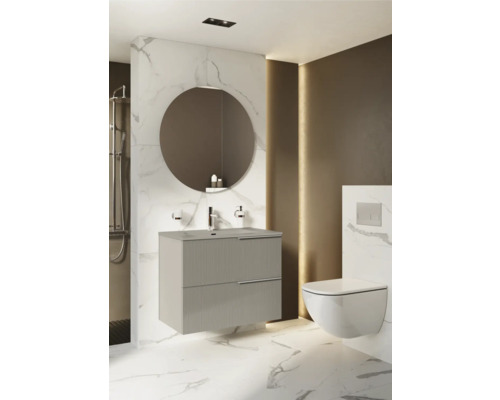 Salle de bains moderne avec meuble sous-lavabo, miroir rond et WC suspendu.