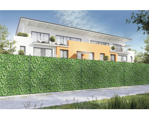 Clôture de confidentialité avec motif de feuilles devant une maison.