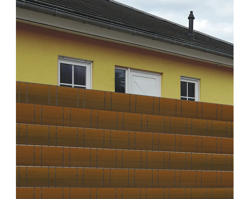 Sichtschutzzaun vor einem gelben Haus