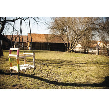 Balancoire en bois avec accents colorés dans le jardin