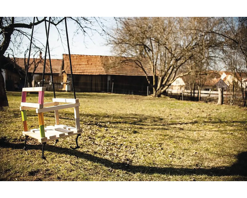 Balancoire en bois avec accents colorés dans le jardin