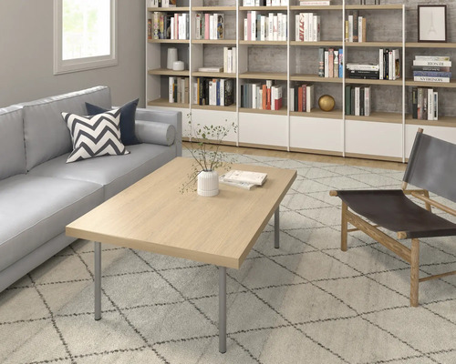 Wohnzimmer mit Sofa, Couchtisch, Sessel und Bücherregal