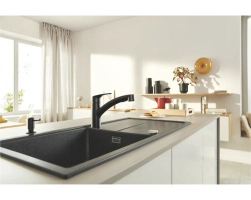 Küchenszene mit dunkler Spüle, Armatur und Seifenspender auf einer Kücheninsel