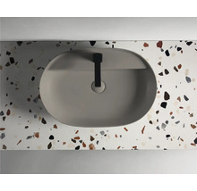 Vasque à poser en céramique sur un plan de toilette avec motif terrazzo et robinet