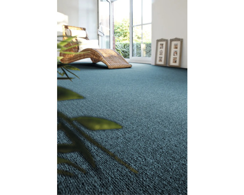 Moquette bleue dans une pièce lumineuse avec des meubles en osier et une plante d''intérieur