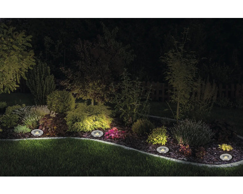 Jardin avec éclairage encastré au sol la nuit