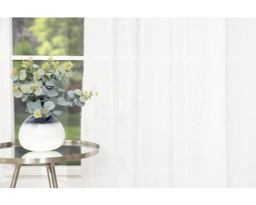 Eukalyptus in Vase auf Beistelltisch vor Fenster mit Vorhang