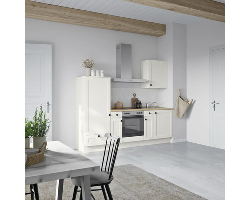 Helle Küche mit Küchenzeile, Dunstabzugshaube, Hängeschrank, Spüle und Esstisch