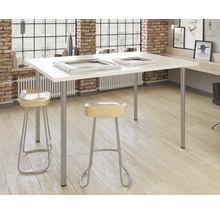 Pièce lumineuse avec table blanche, deux tabourets et cadres