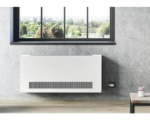 Weißer Heizkörper an einer grauen Wand unter einem Fenster