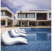 Piscine avec chaises longues et maisons résidentielles modernes en arrière-plan