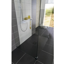 Ebenerdige Dusche mit Duschrinne, Duscharmatur und Glaswand in einem modern gestalteten Badezimmer.
