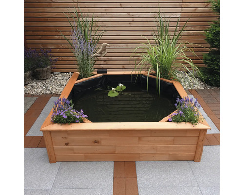 Bassin en bois avec plantes et nénuphars dans le jardin