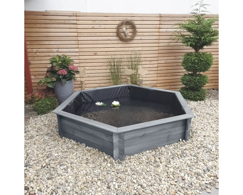 Hexagonaler Gartenteich aus Holz mit Wasserpflanzen in einem gepflegten Garten