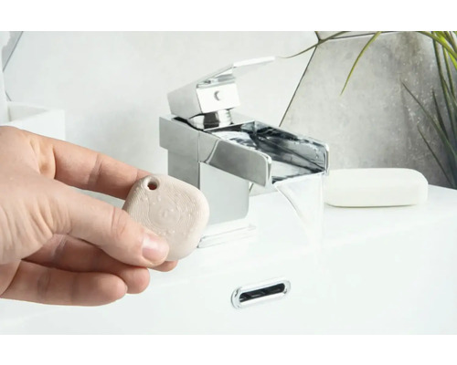 Szene im Badezimmer mit Wasserhahn und Duftstein