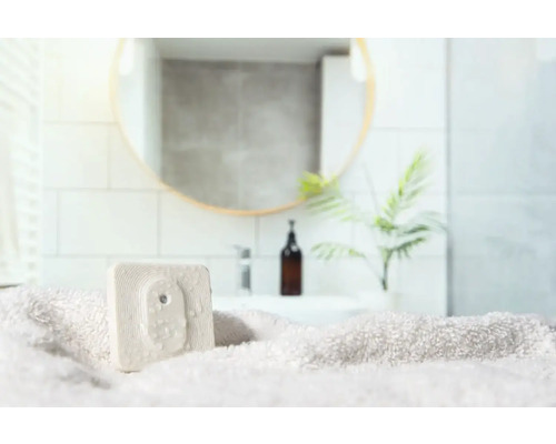 Scène de salle de bains avec serviette et désodorisant