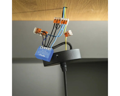 Shelly Relais verbunden mit elektrischen Leitungen und Wago Klemmen an einer Deckenhalterung